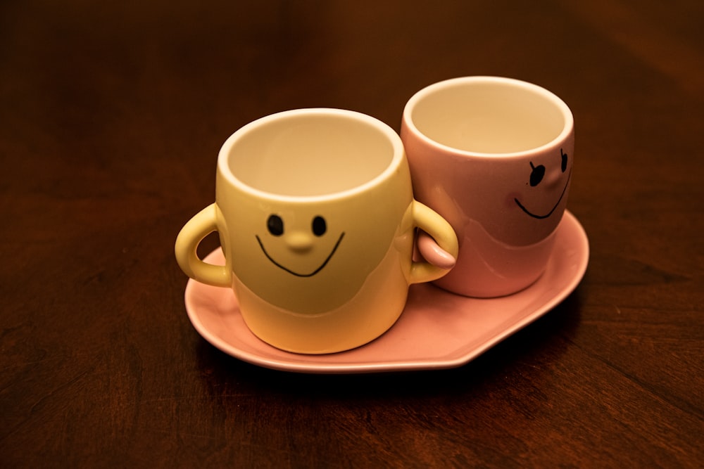 white and red ceramic mugs on white ceramic plate