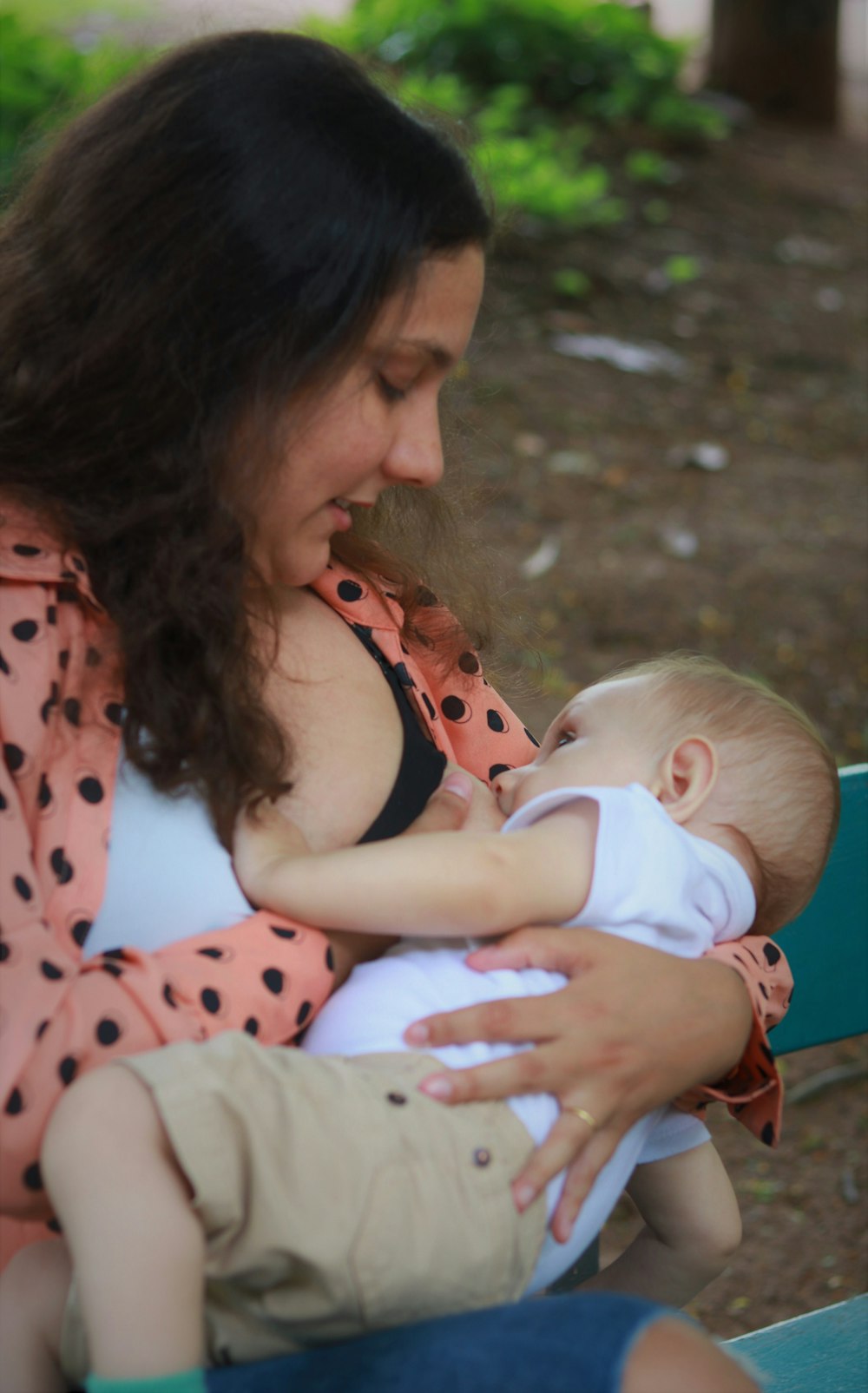 Femme en chemise à pois rouge et blanc portant bébé