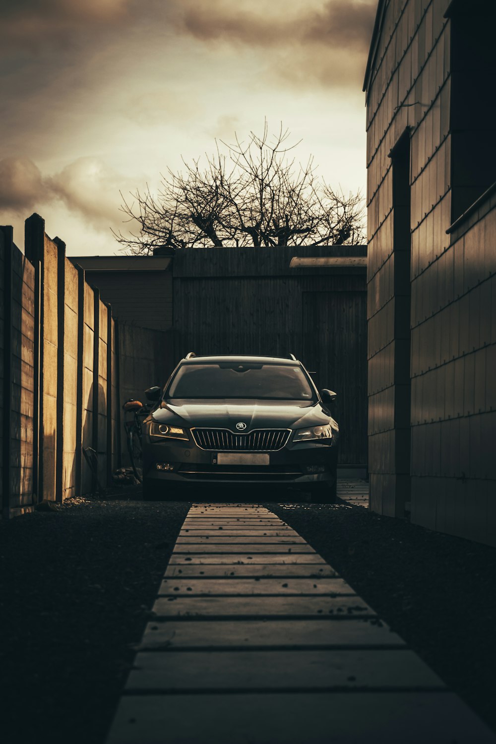 Photo en niveaux de gris d’une voiture garée à côté d’un bâtiment