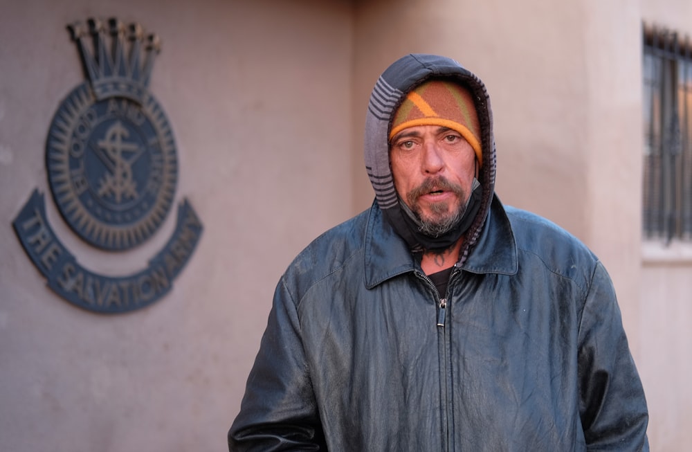 man in black zip up jacket wearing orange knit cap