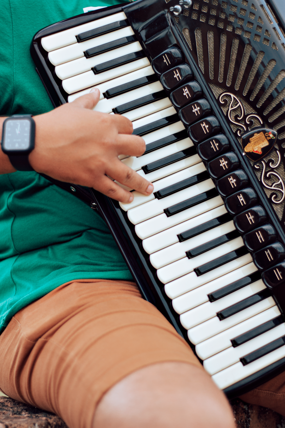 person in green shirt playing piano