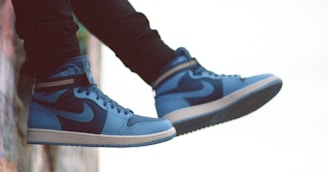 person wearing blue and white nike sneakers