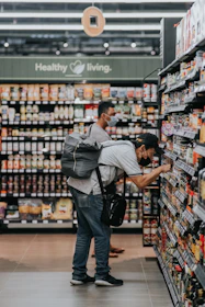 man in gray polo shirt and blue denim jeans standing on grocery store