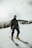 man in black jacket and black pants riding on red and white ski blades on snow