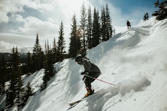 man in black jacket and blue pants riding ski blades on snow covered mountain during daytime