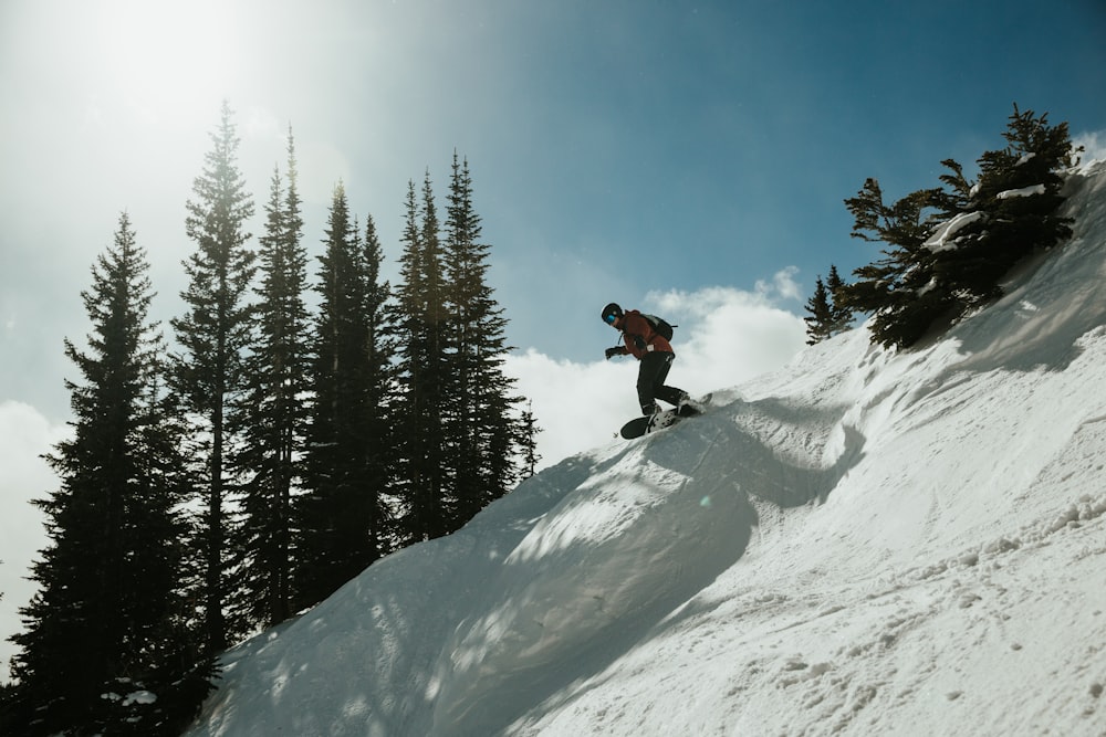 man in black jacket and black pants standing on snow covered mountain during daytime