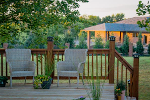 A charming back porch upgrade with PVC decking and privacy screens surrounded by greenery