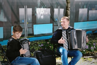 man in black jacket playing black and white electric piano