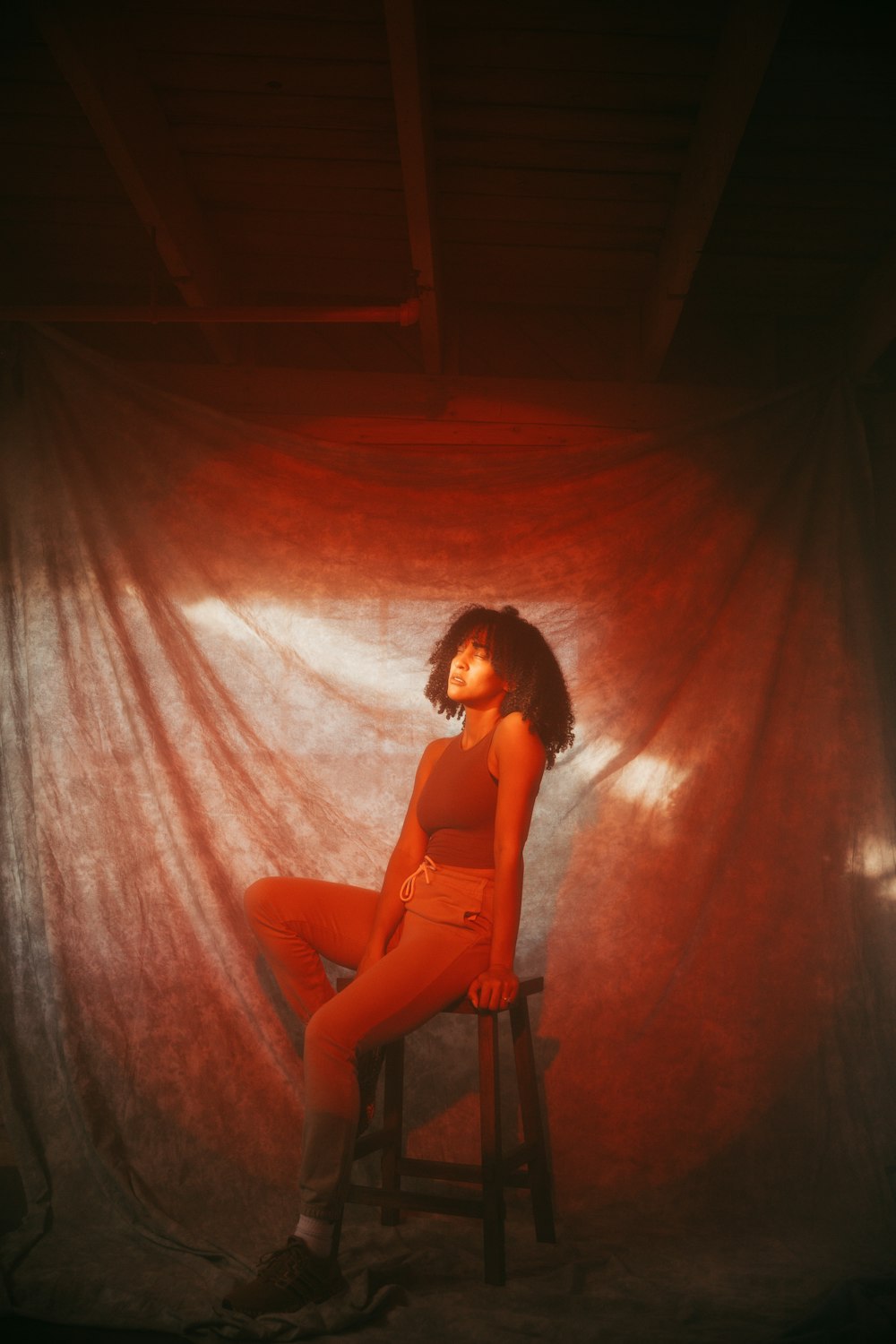 woman in black brassiere and red pants sitting on chair