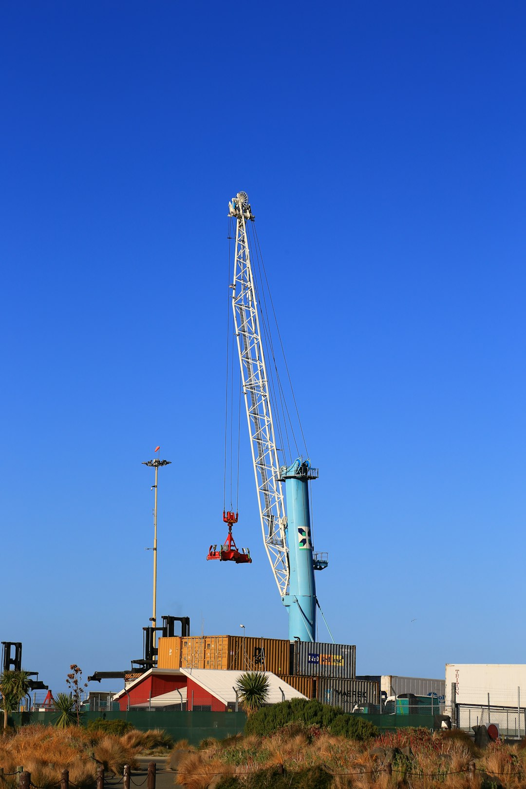 white and red crane under blue sky during daytime