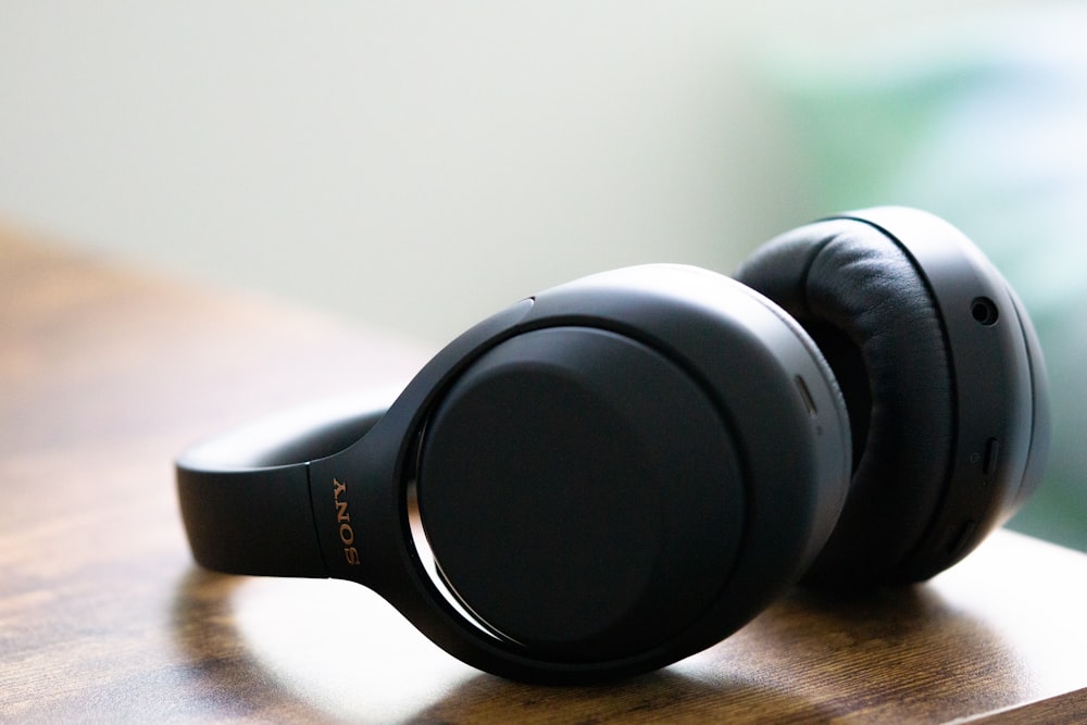 black and gray headphones on brown wooden table