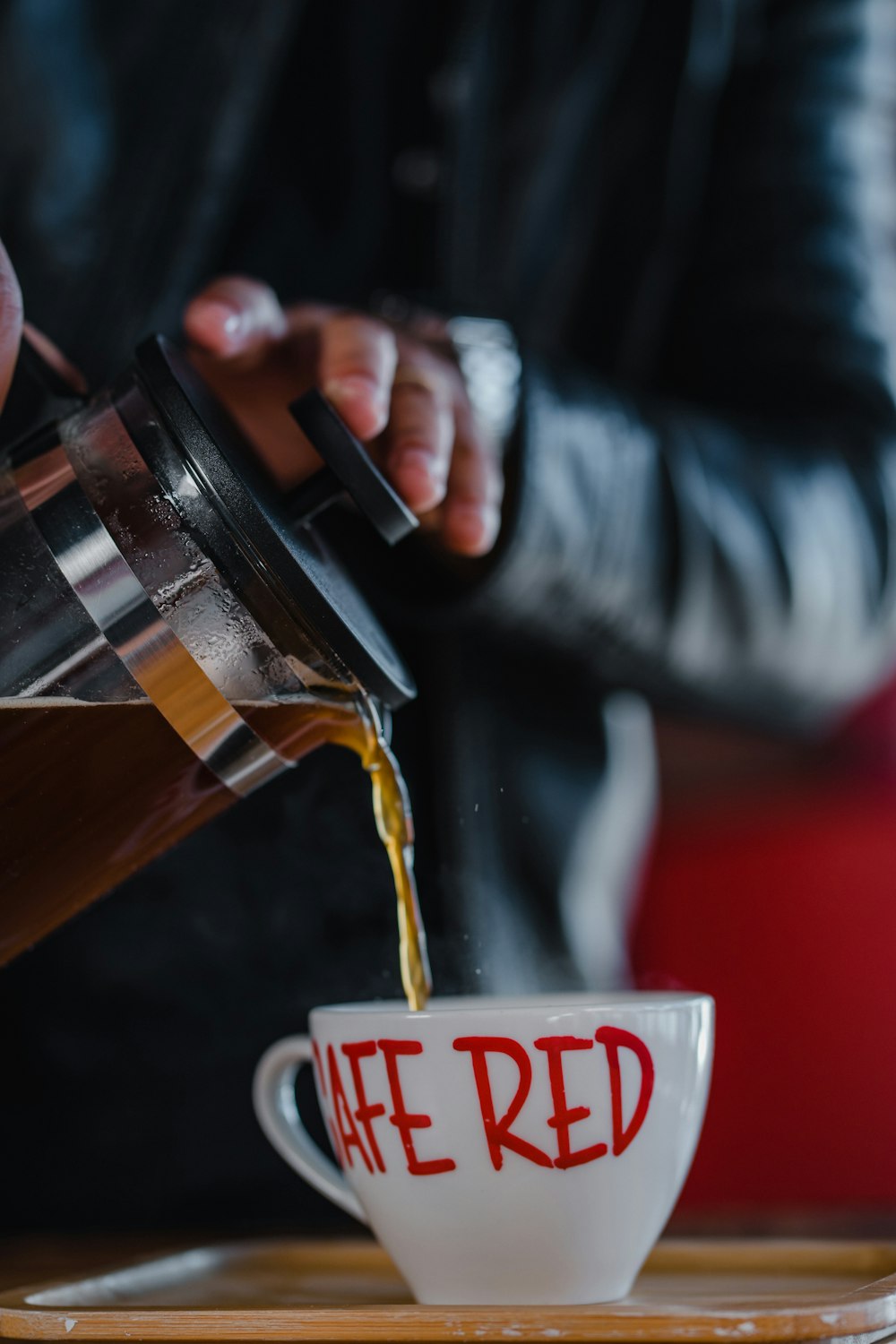 person holding brown and black plastic cup