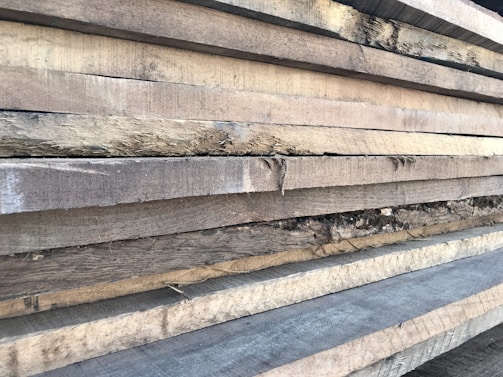 Stack of raw solid wood planks ready to be crafted into elegant rustic shelves.