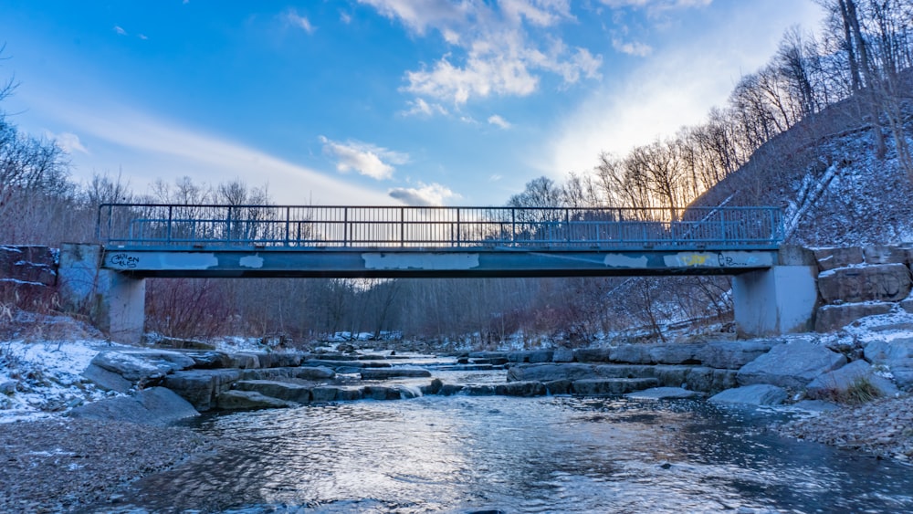 bridge over river under blue sky during daytime