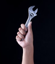 person holding gray and black metal tool