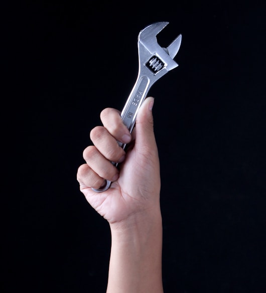 person holding gray and black metal tool