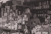 Happy small business owner holding their tap card with a backdrop of their busy shop.