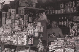 Happy small business owner holding their tap card with a backdrop of their busy shop.