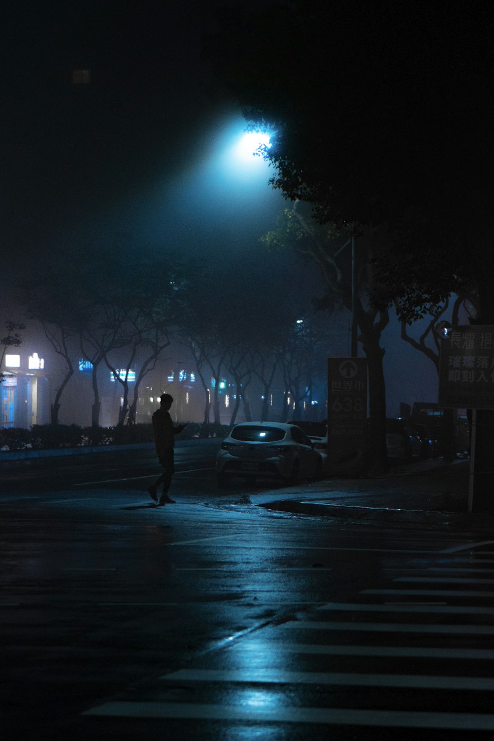 man walking on street during night time