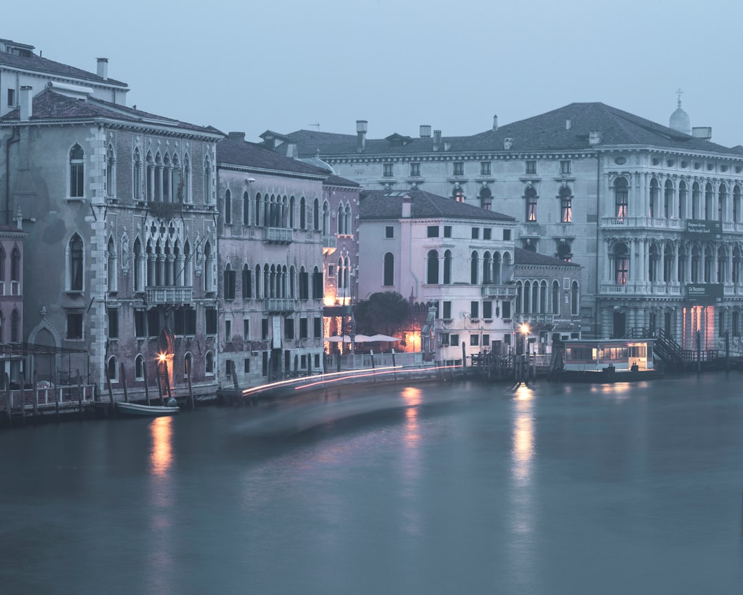 white and brown concrete building beside river during night time