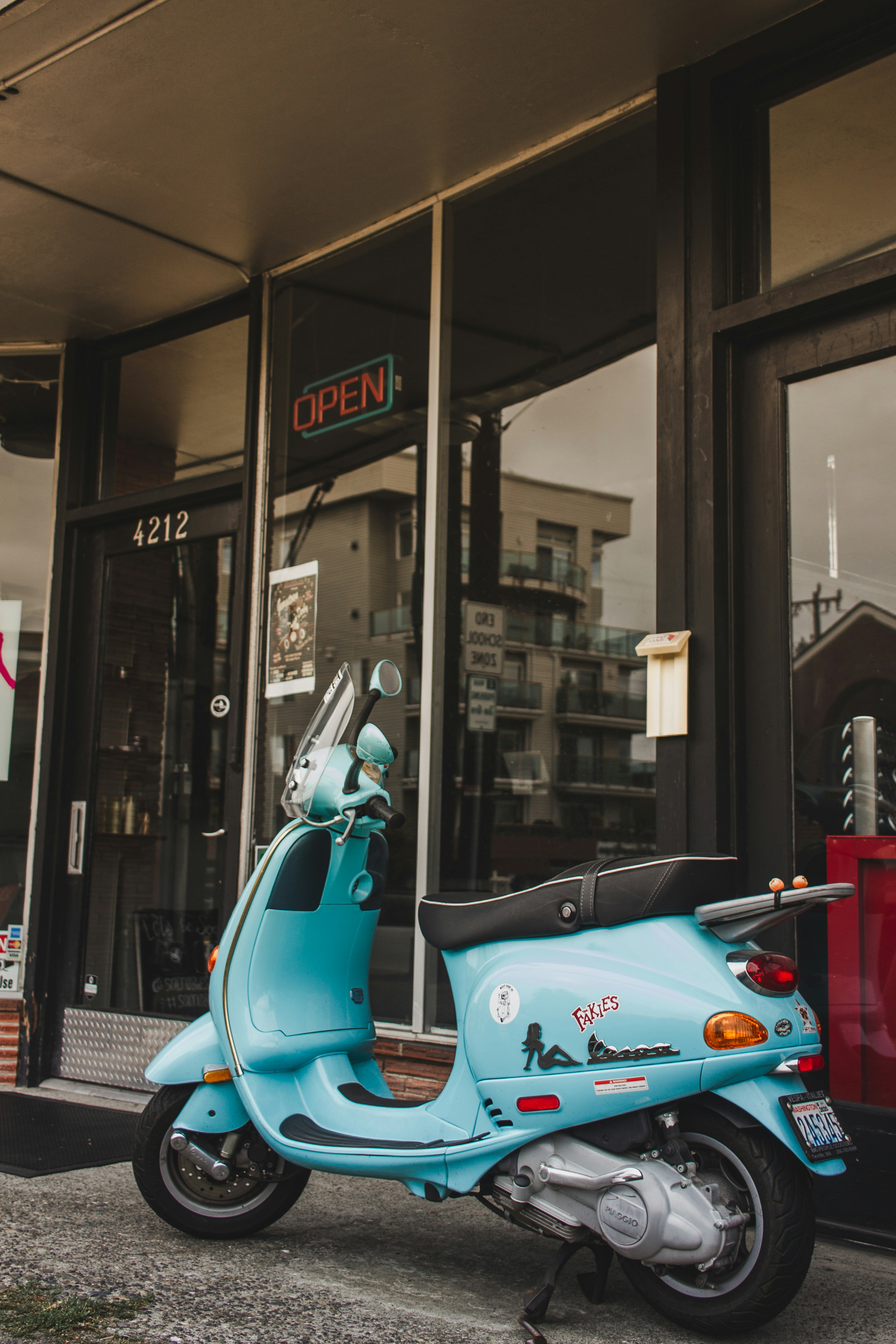 Scooter bleu et blanc garé à côté du magasin pendant la nuit