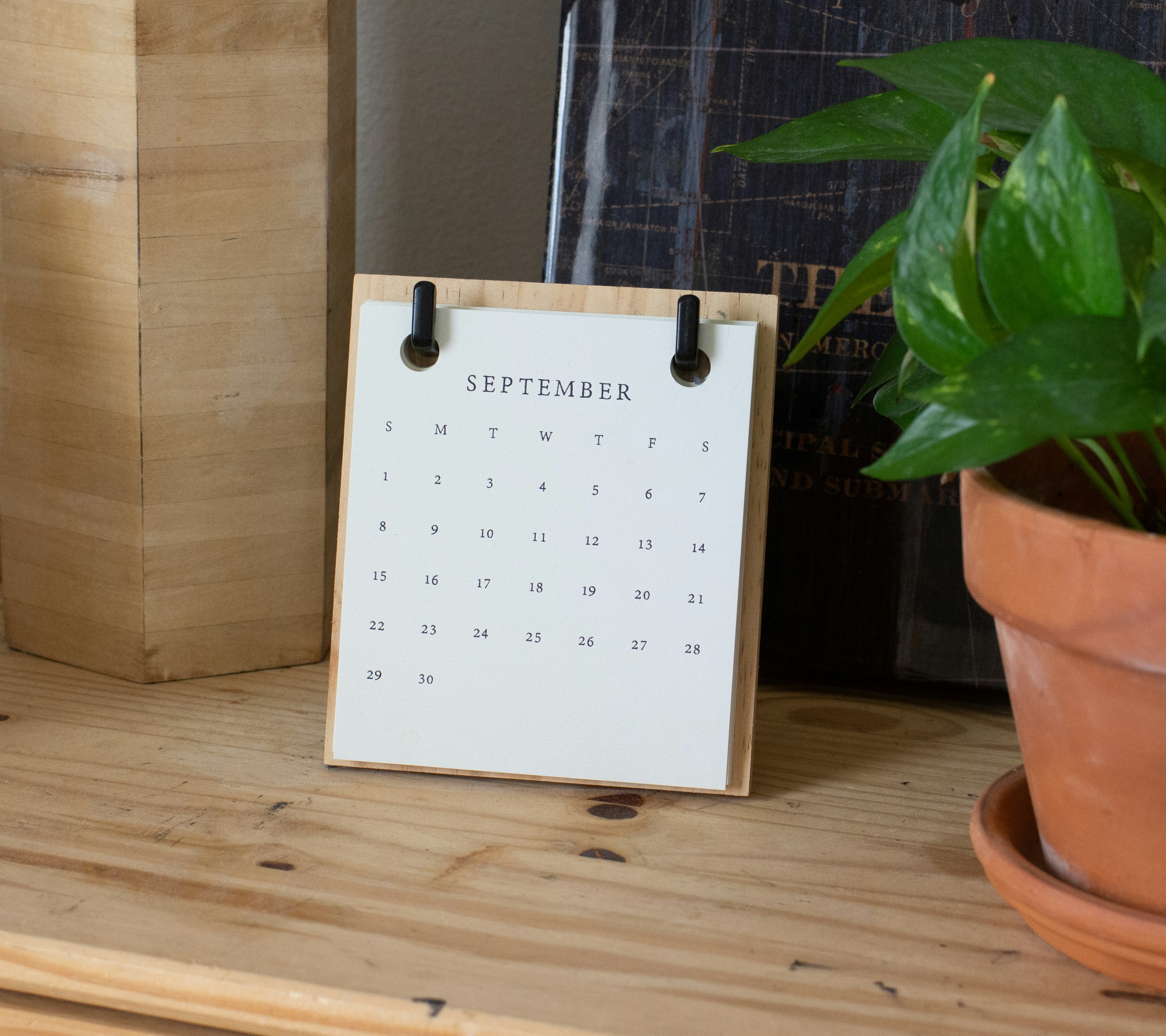 Dresser top with mini calendar of September and potted plant