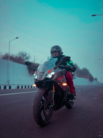 A vibrant sports bike speeding along a coastal highway under clear skies.