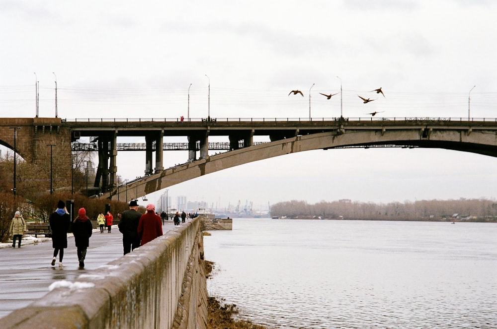 people walking on bridge over river during daytime