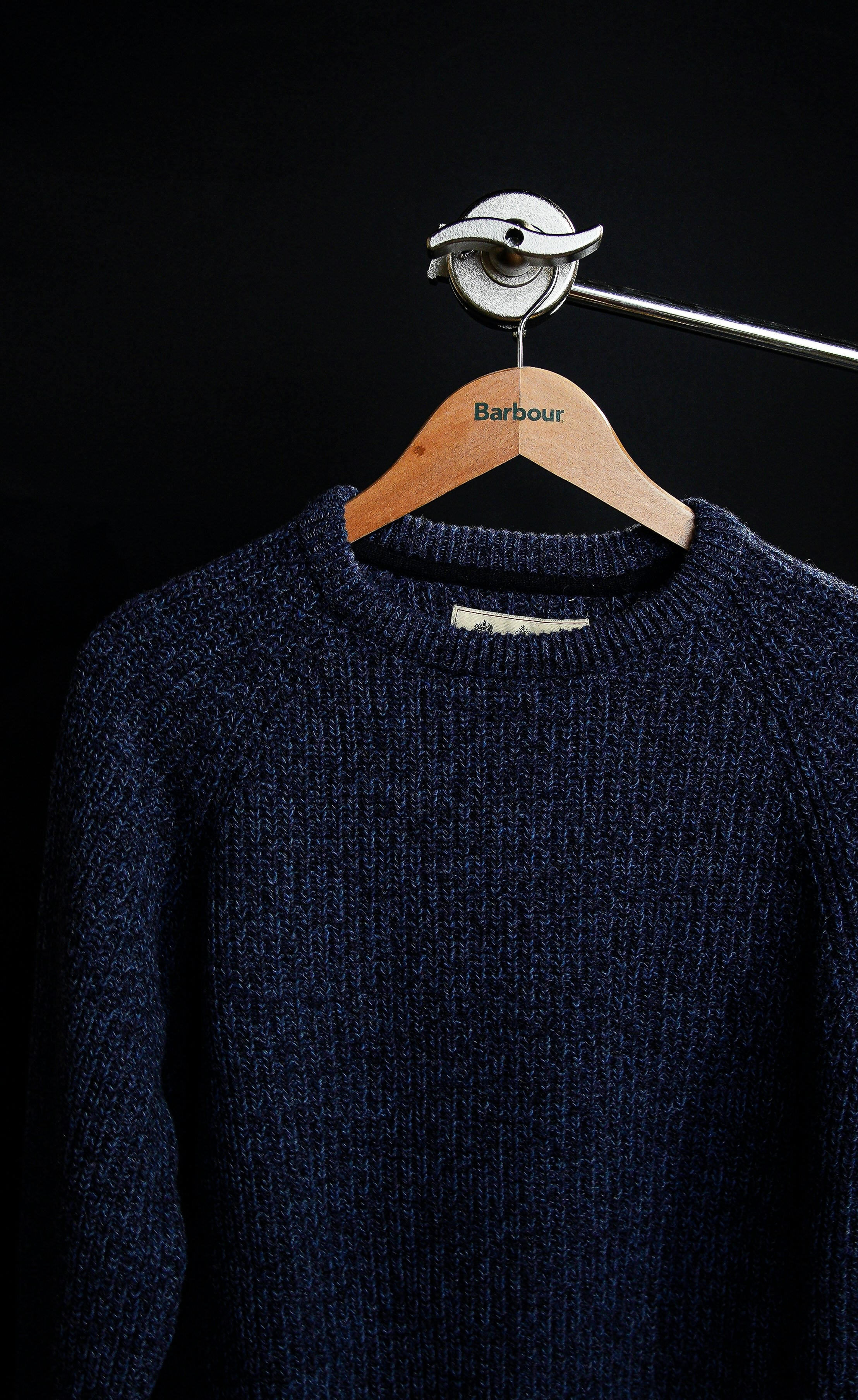black crew neck sweater on white clothes hanger
