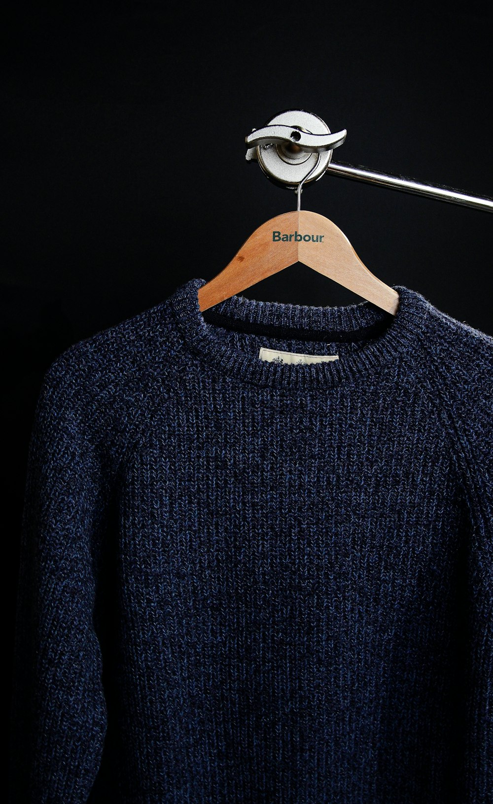 black crew neck sweater on white clothes hanger