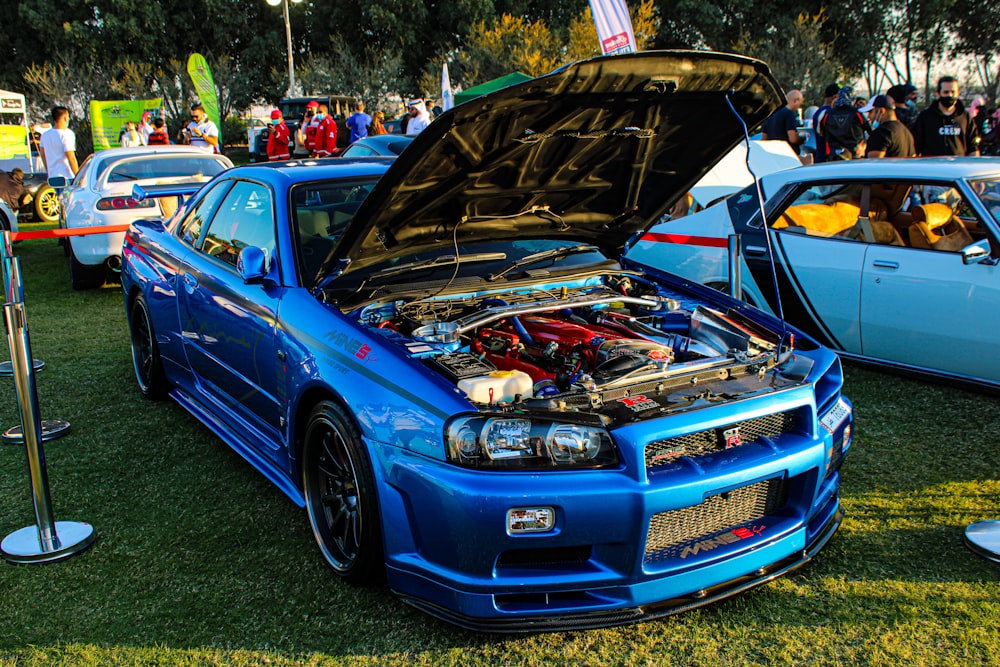 blue chevrolet camaro on green grass field during daytime