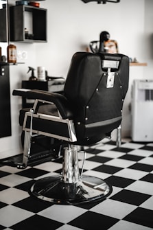 black leather barber chair in white room