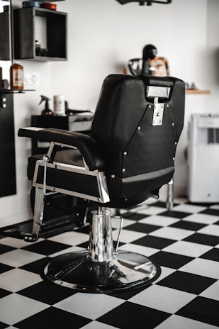 black leather barber chair in white room
