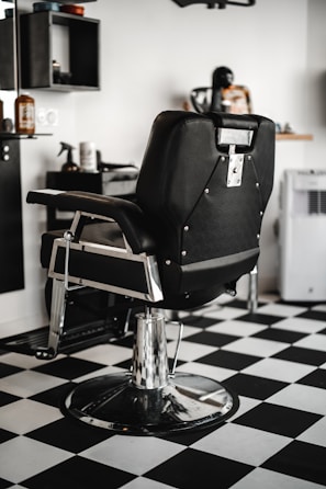 black leather barber chair in white room