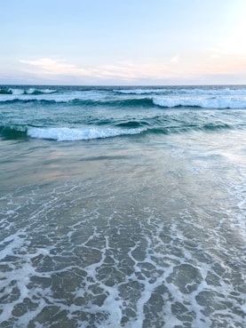 ocean waves crashing on shore during daytime