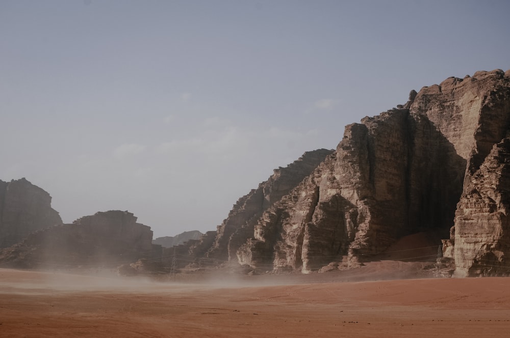 Montagne rocheuse brune près d’un plan d’eau pendant la journée