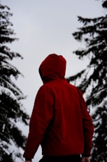 person in red hoodie standing on snow covered ground