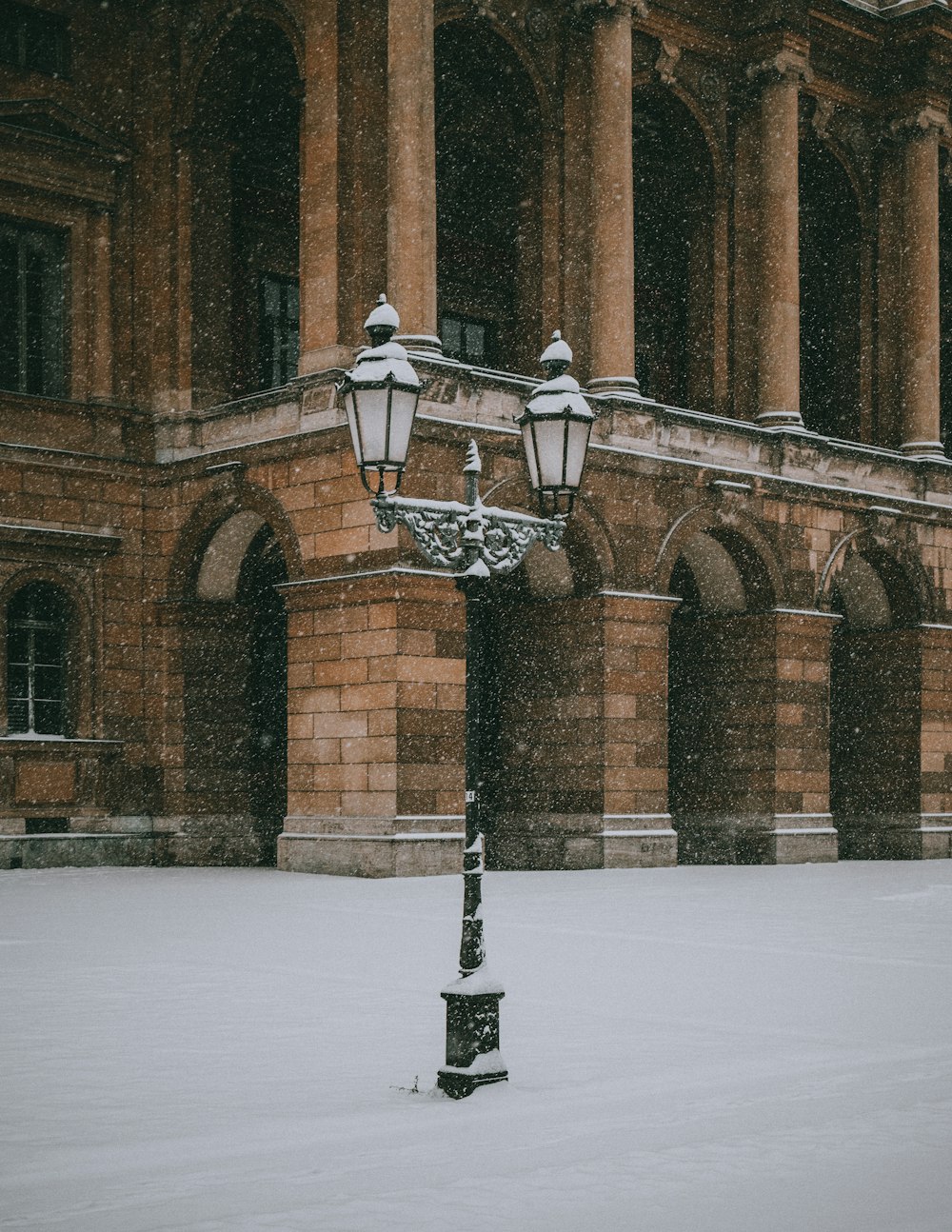 black and white lamp post on snow covered ground