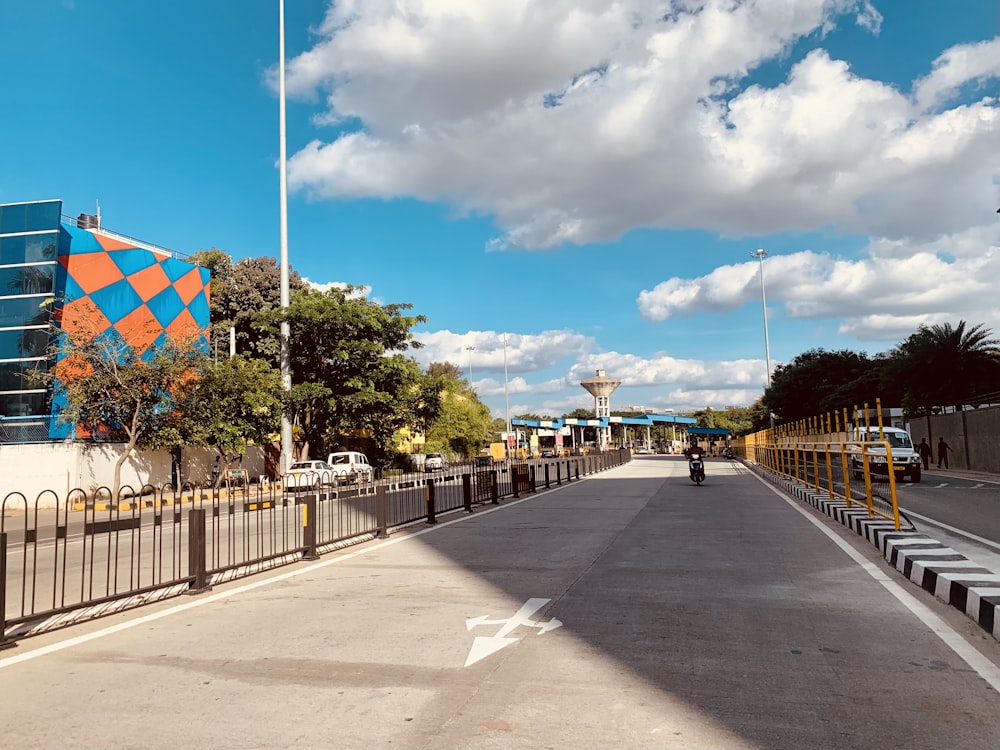 pessoas andando em um caminho de concreto cinza sob o céu azul durante o dia