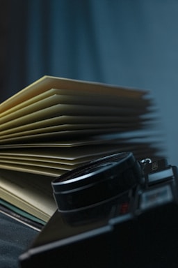 black and silver camera on books