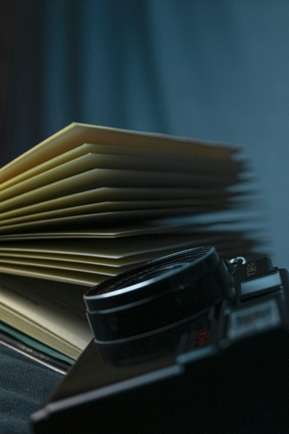 black and silver camera on books