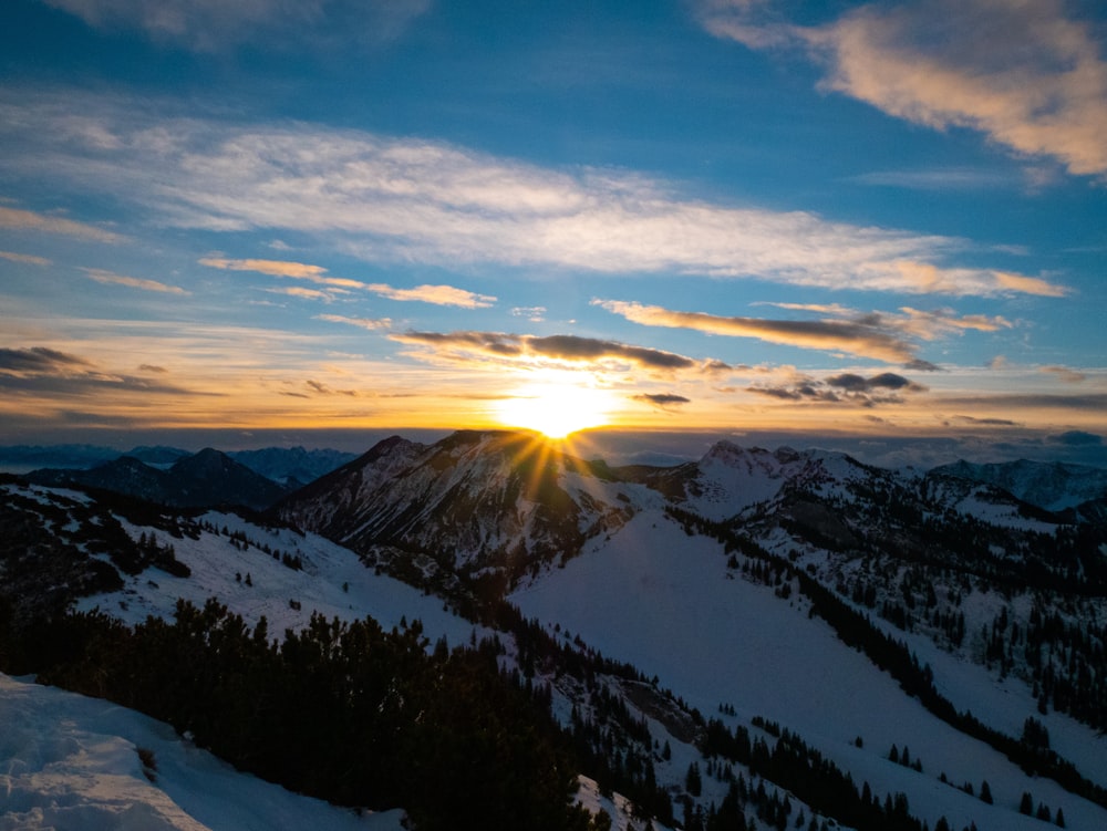 snow covered mountains under cloudy sky during daytime