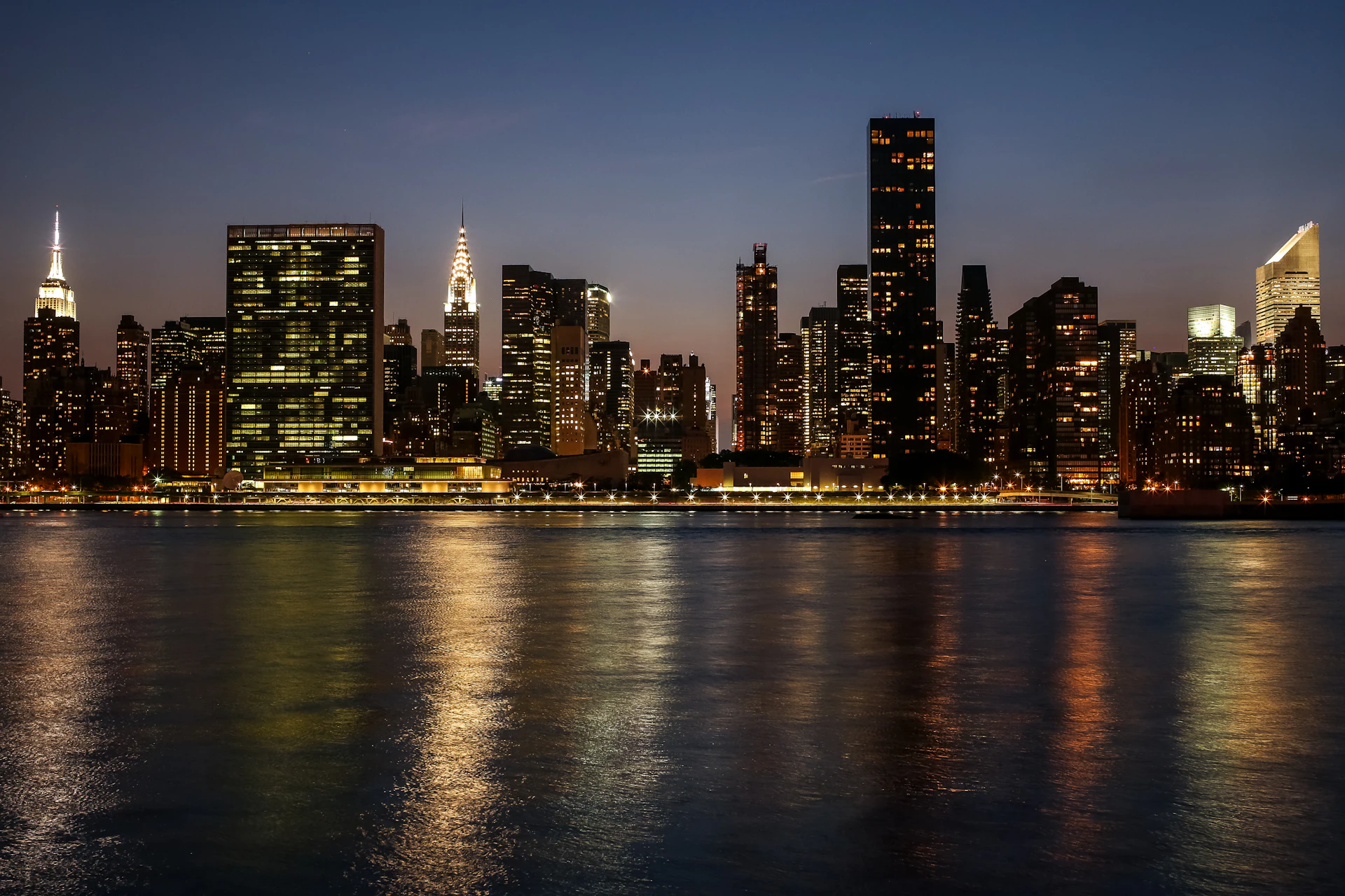 City skyline reflected across water at night