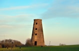 A square tower standing tall in an open field.