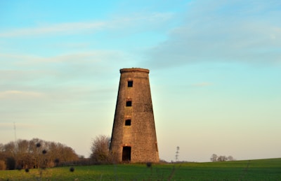 A square tower standing tall in an open field.