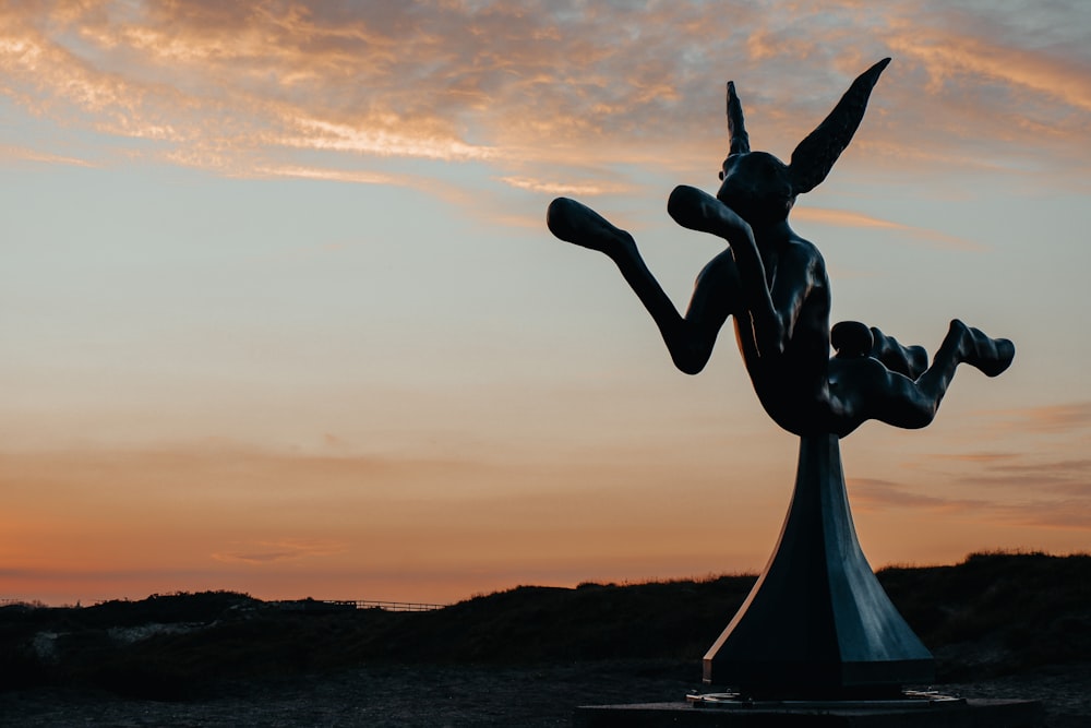 silhouette of woman raising her hands during sunset