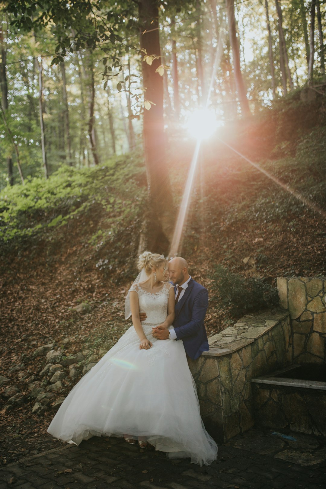 woman in white wedding gown standing on gray concrete stairs