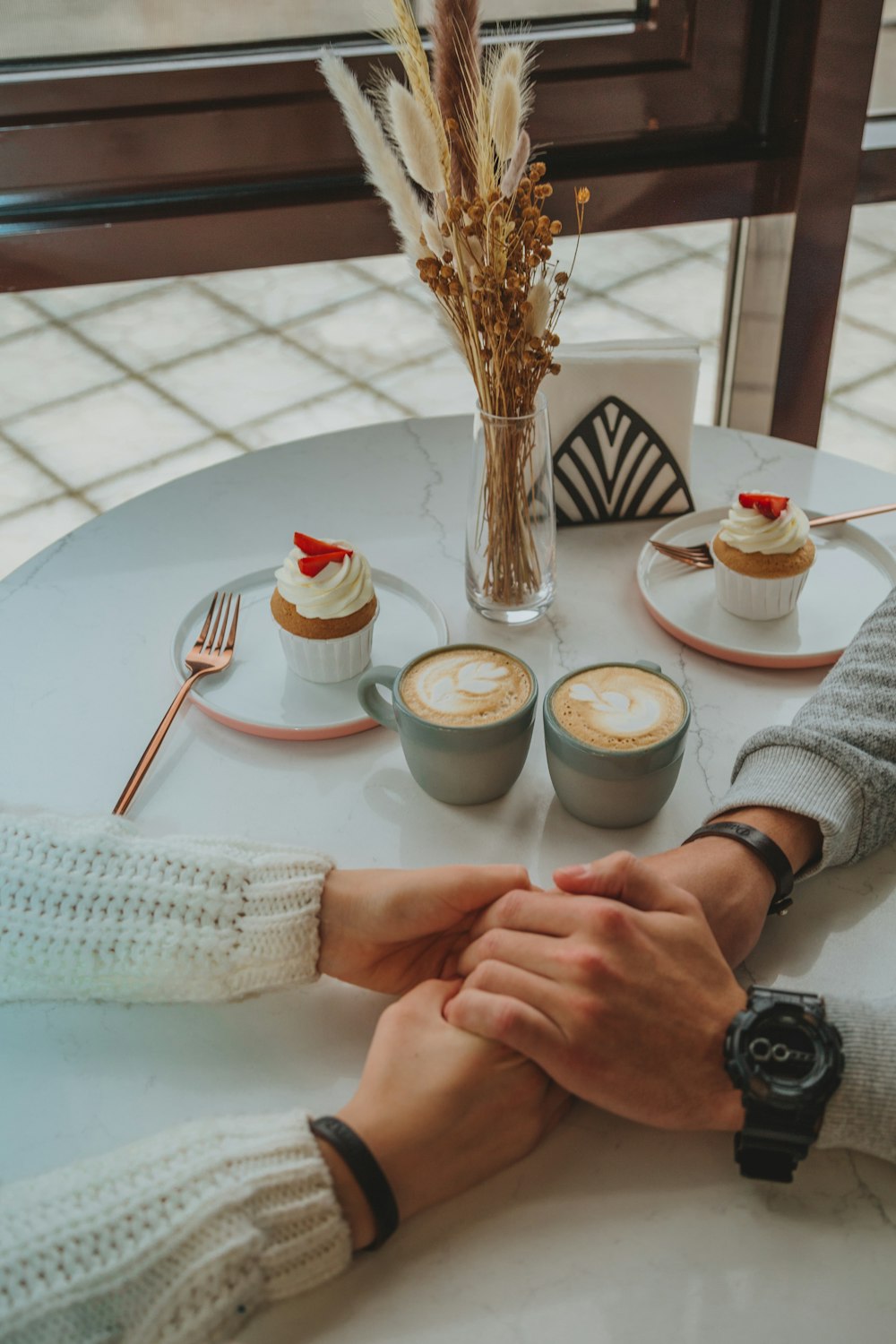 person in white sweater holding white ceramic bowl