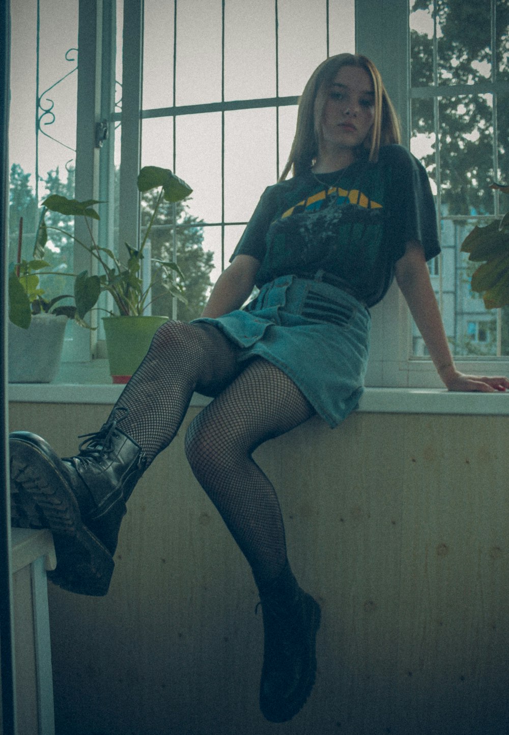 woman in black and blue dress sitting on window