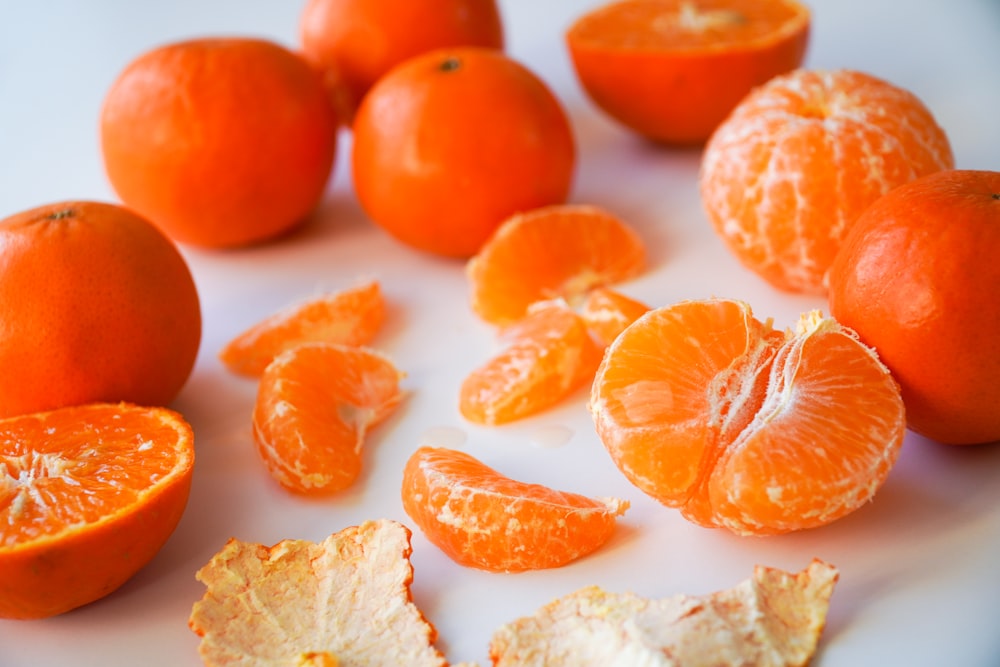 Fruits oranges tranchés sur assiette en céramique blanche